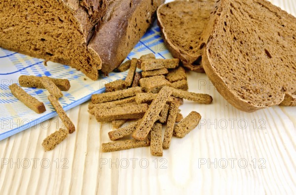 Rye homemade bread, crackers, blue cloth on a background of wooden boards