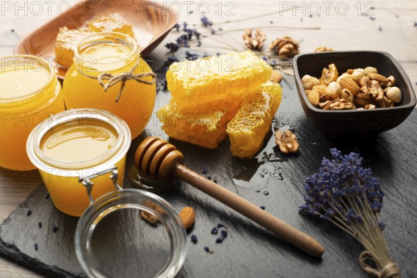 Honeycomb on slate tray with honey and nuts on kitchen table, food photography, food photography