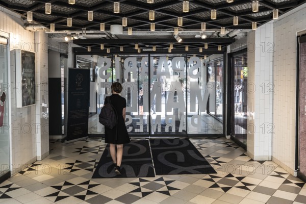 Uppsala, Uppland Sweden, 07 27 2019 Beautiful thirty year old woman in black dress walkig out of the Svava Matgalleria shopping mall