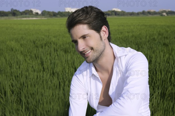 Young man outdoor happy relaxed on green rice field meadow