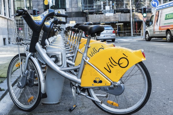 Belgium, 02 15 2019: Villo station with a row of yellow cycles for sharing and renting in the city, Europe