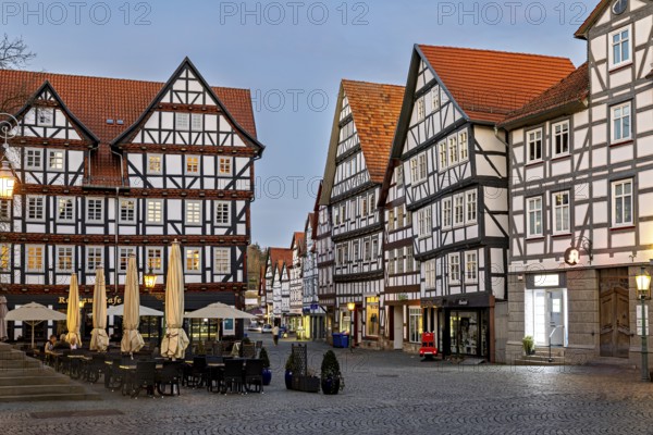 Illuminated half-timbered buildings in the evening mood on a market square, The old town centre of Melsungen