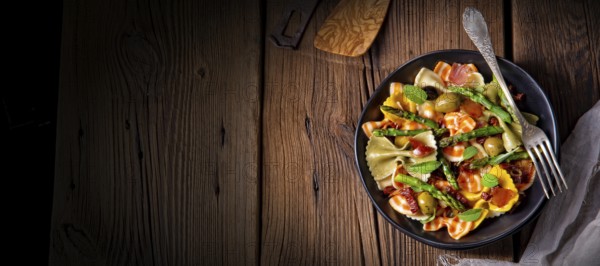 Pasta salad with green asparagus, olives and Parma ham