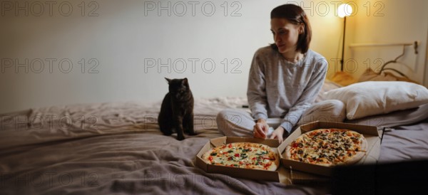 Woman and cat on bed with pizzas, soft lighting creating a cozy vibe