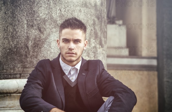 Handsome young man outdoor wearing jacket and shirt standing by historic building in European city. Turin, Italy, Europe
