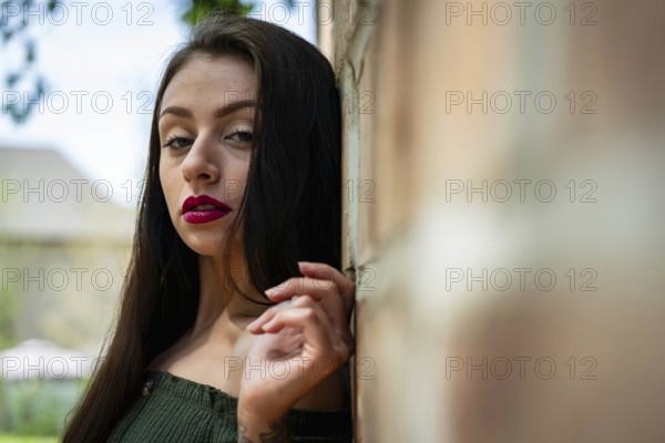 A stunning young brunette poses outdoors in a flowy white spring dress, her hair cascading in soft waves. She smiles, basking in the gentle warmth of spring after enduring a long, harsh winter, Charlotte, United States of America