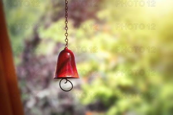An image of a red color bell in the garden with bokeh background
