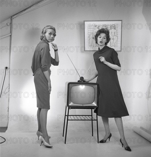 Television in the 1950s. Two young women are standing dressed in a typical 50s dress beside a televison set with an table antenna on top of it. In 1952 1.4 million households in Britain had a television. Photo Kristoffersson ref BZ26. Sweden 1952