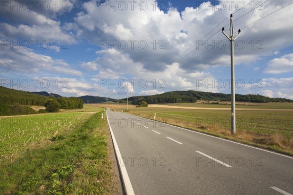 On the empty road between summer field