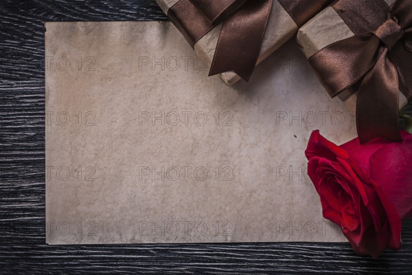 Vintage paper red natural rose wrapped giftboxes on wooden board