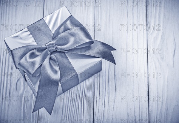 Packaged gift box on wooden board top view holidays concept