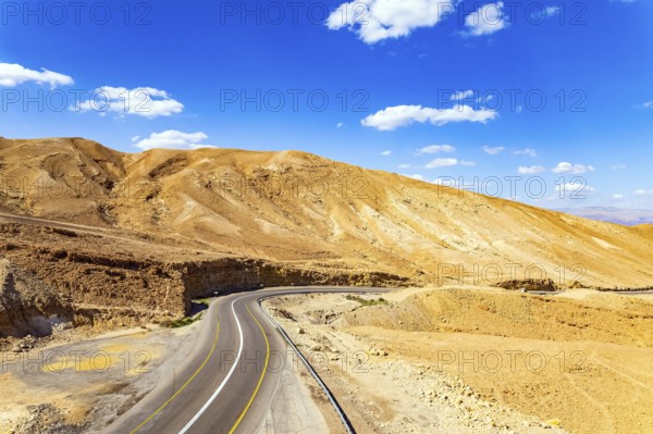 Desert on the shores of the Dead Sea. Israel. Asphalt highway meanders among the hills. Dead Sea mud has healing properties. Drone filming
