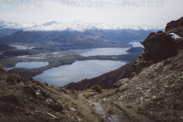 Rocky path with views of several lakes and valleys between the mountains, Roys Peak, Wanaka, New Zealand, Oceania