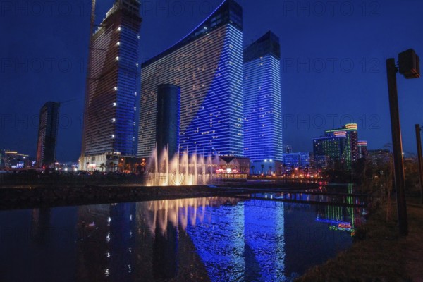 Orbi Beach Tower Batumi Aparts in blue hour. Reflection in pond of 2 skyscrapers (Orbi) and other buildings along the beach