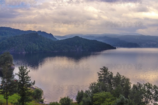 Evening at the fjord in West Norway with beautiful golden Clouds in the sky. Evening at the fjord in Norway with beautiful golden clouds in the sky