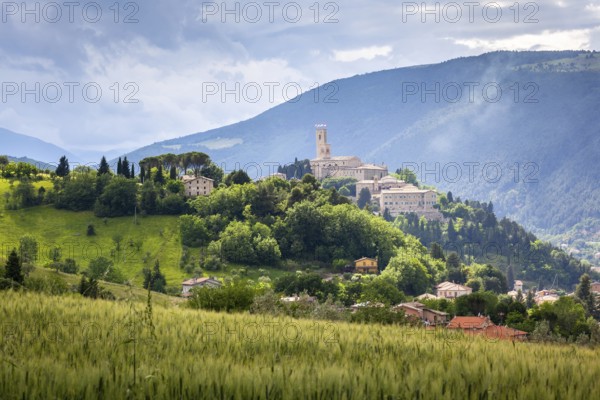 An image of Camerino in Italy Marche over colourful fields