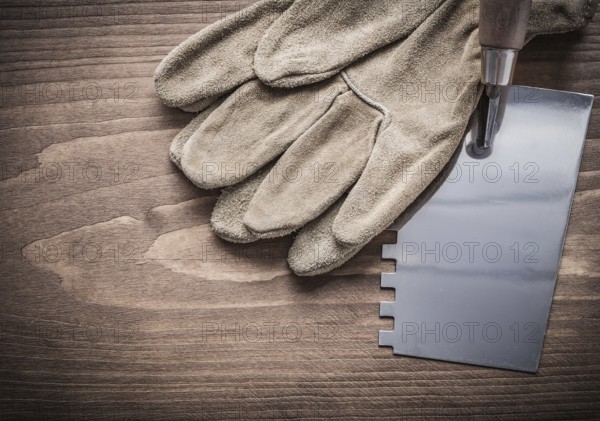 Working gloves and putty spattle on wood board