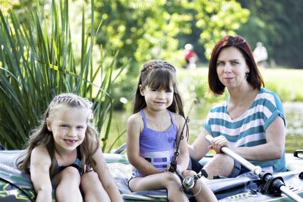 Family fishing on lake at summer