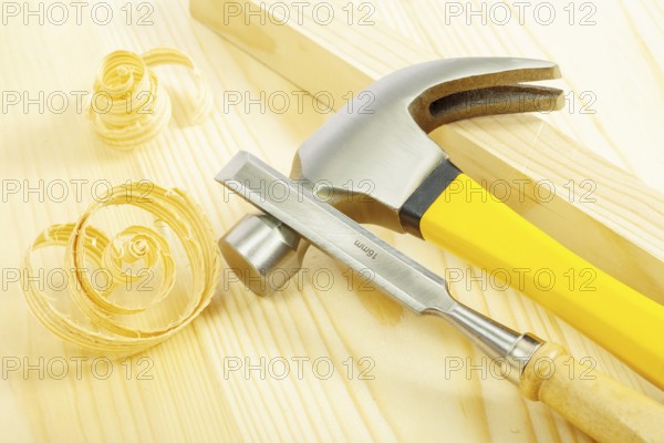 Claw hammer and chisel on wooden board