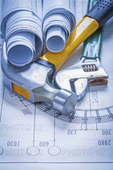 Blueprint rolls adjustable spanner and claw hammer construction concept