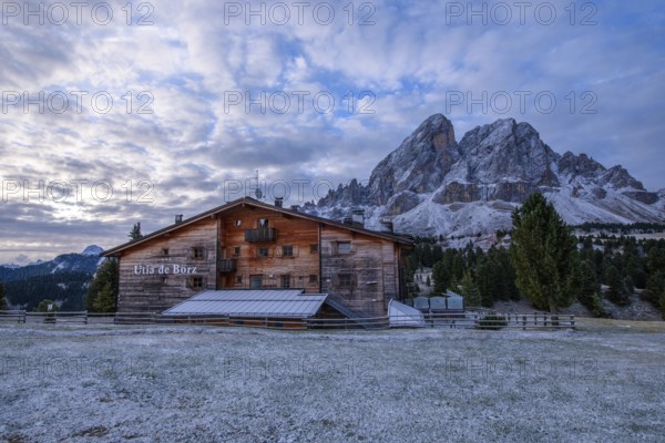 Utia de Borz hut in Passo Erbe after sunrise at the mountain Peitlerkofel, or Sass de Putia