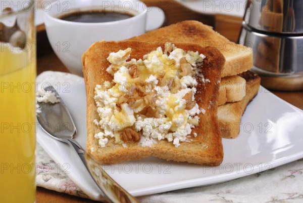 Crisp, fresh toast ricotta, honey and nuts for breakfast with orange juice and coffee