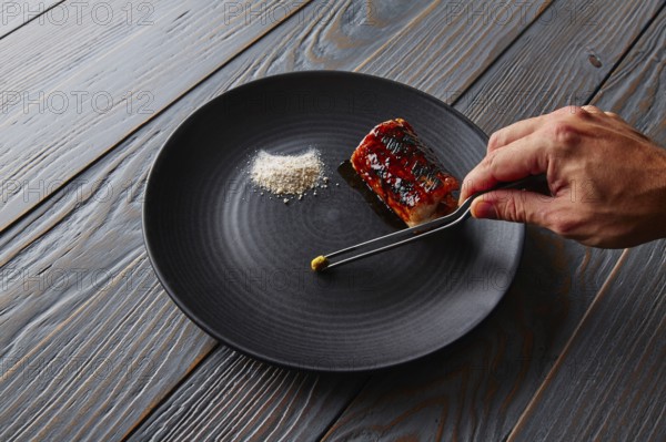 Grilled smoked eel with green apple and citrus chef hand preparing