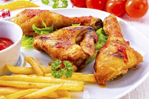 Grilled chicken wings, legs, chips and vegetables