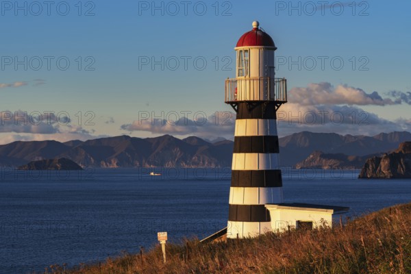 Petropavlovsky Lighthouse founded in 1850 located on Kamchatka Peninsula on shore of Avacha Gulf in Pacific Ocean, vicinity of Petropavlovsk-Kamchatsky City. View of lighthouse in morning at sunrise