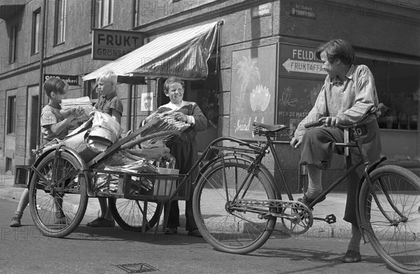 1940s children. Scene from the Swedish movie Kvarterets olycksfågel 1947. The boys are working extra as bicycle messangers and doing deliveries to earn extra money. Sweden 1947