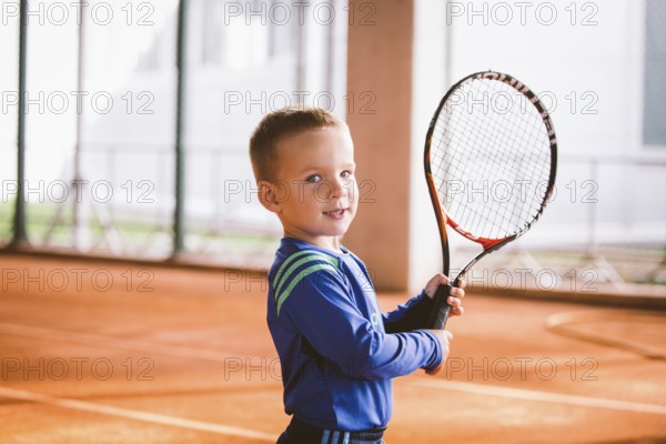 Child playing tennis on outdoor court. September 20, 2016, Ukraine, Kiev. Little tennis great player. Children sportswear adidas. Child athlete Ambassador Adidas, Europe