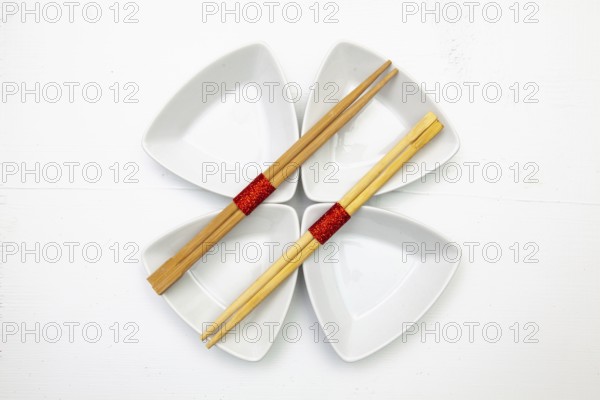Ceramic bowls and bamboo chopsticks for sushi food with red and white decoration