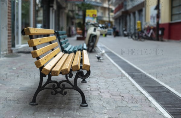 Wooden Bench on the street. No people. Shopping street
