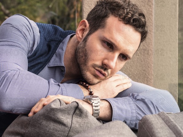 Handsome elegant man at home, wearing shirt and vest, looking away to a side
