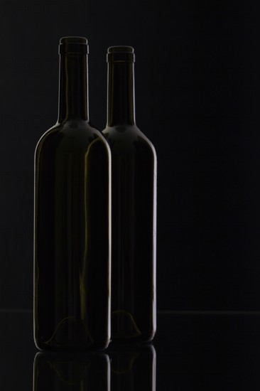 Two different bottles of wine on the black background