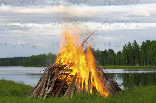 A big fire at a lake shore on Midsummer Day, Finland, Europe