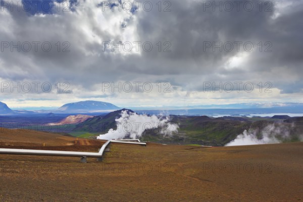 Krafla Lake neighborhood. Summer Iceland. Steam rises above the hot ground. Pipeline to transport hot water