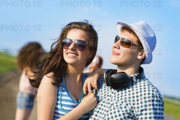 Young couple standing on the road, having fun with friends