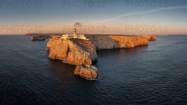 Portuguese coast with a lighthouse in the rays of the setting sun, Cabo De Sao Vincente on sunset