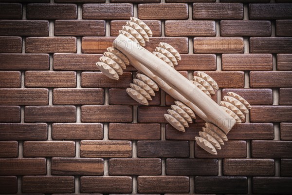 Wood massager with handle on textured wooden mat healthcare concept
