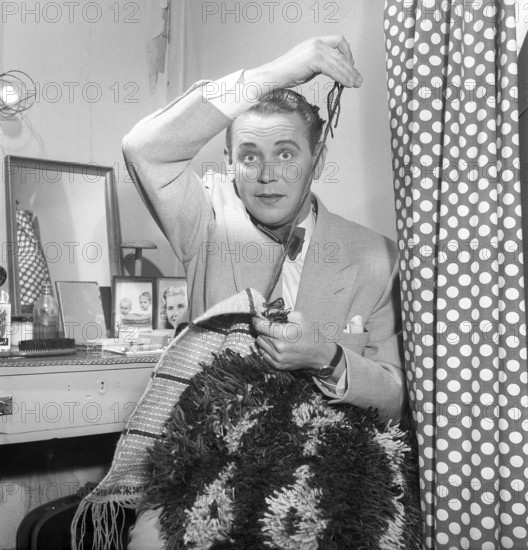 Max Hansen 1953 Danish actor, singer and performer. Appeared in many revues and films in Sweden. Here in his dressing room at the theater where he passes the time making a rya rug. 1953. Kristoffersson ref BL105-1
