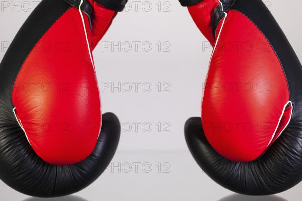 Red and black boxing gloves on a glass table isolated on white background