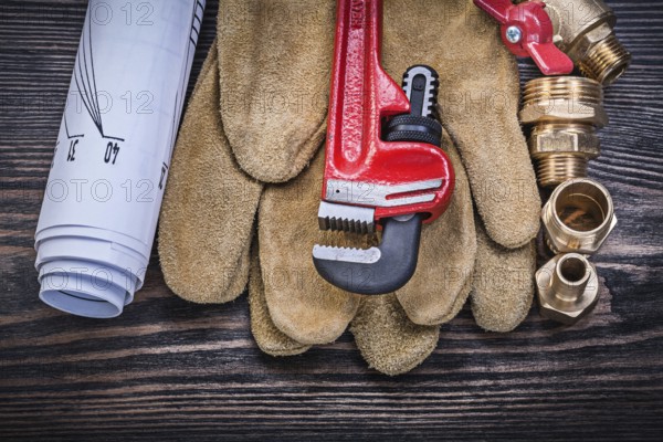 Protective gloves monkey wrench construction drawings brass plumbing fittings gate valve on wooden board