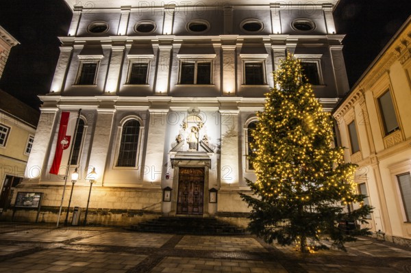 Illuminated Christmas tree in front of church, St. Xaver parish church, night shot, Leoben, Styria, Austria, Europe