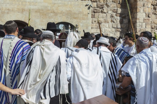 JERUSALEM, ISRAEL - OCTOBER 12, 2014: Morning autumn Sukkot. The area in front of Western Wall of Temple filled with people. Crowd of faithful Jews wearing prayer shawls