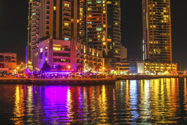 Dubai Marina Walk illuminated at night. Dubai Marina is a newly futuristic district, famous for restaurants, luxury clubs, and nightlife