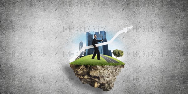 Conceptual image of young and confident business man in suit holding big white arrow in hands while standing on flying island against gray concrete background