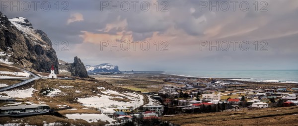 An aerial view of a chapel on top of a hill over Vik, Iceland in the middle of a field. Photo of a house nestled in the stunning Icelandic landscape