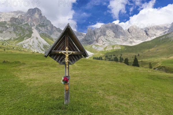 Crucifix in the meadows of Fuciade Valley in the Dolomites