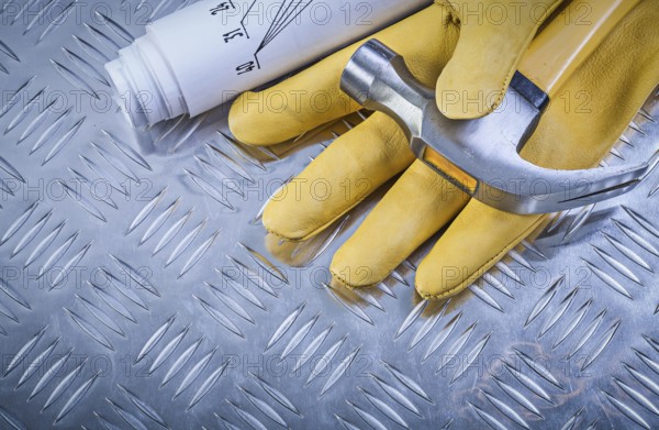 Claw hammer leather protective gloves construction drawings on corrugated metal sheet